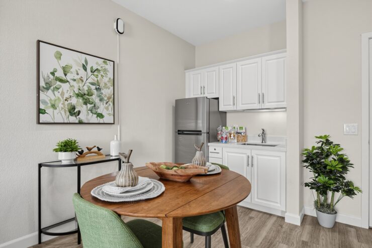 Bright kitchen and dining area with modern appliances, greenery, and inviting seating.