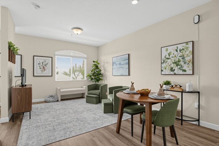 Bright living area with seating, dining table, and nature-inspired artwork for a welcoming community.