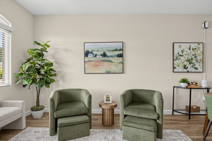 Bright, inviting living area with comfortable seating, art, and greenery for a warm community feel.