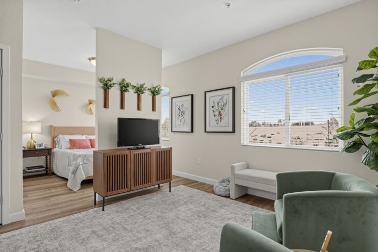 Bright living area with comfortable seating, natural light, and a welcoming bedroom nearby.