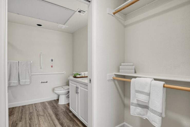 Bright, accessible bathroom and walk-in closet with clean towels, promoting comfort and care.