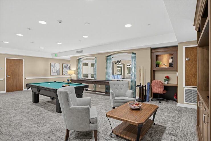 Recreation room with seating, pool table, and a small workspace fostering community and relaxation.