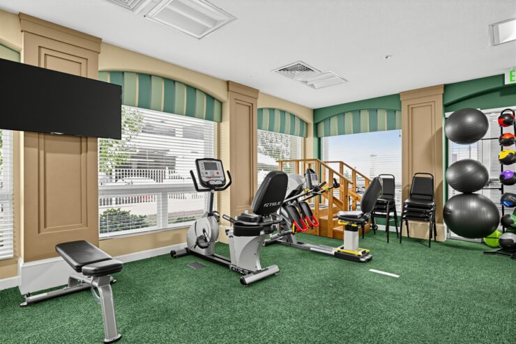 Bright wellness room with exercise equipment and seating, promoting active senior living.