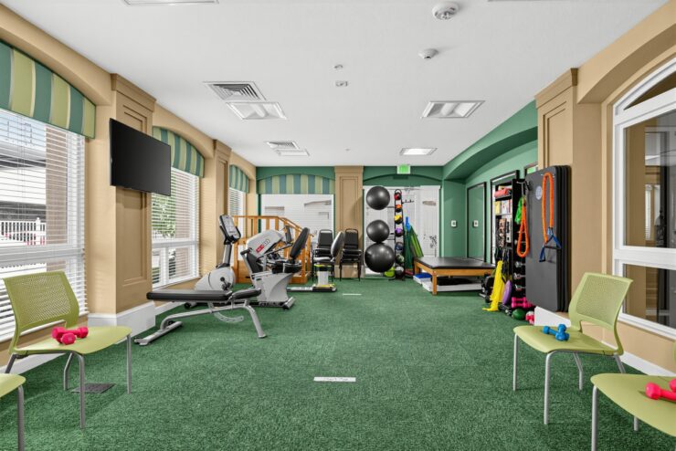 Bright and inviting fitness room with exercise equipment and seating for relaxation and socializing.