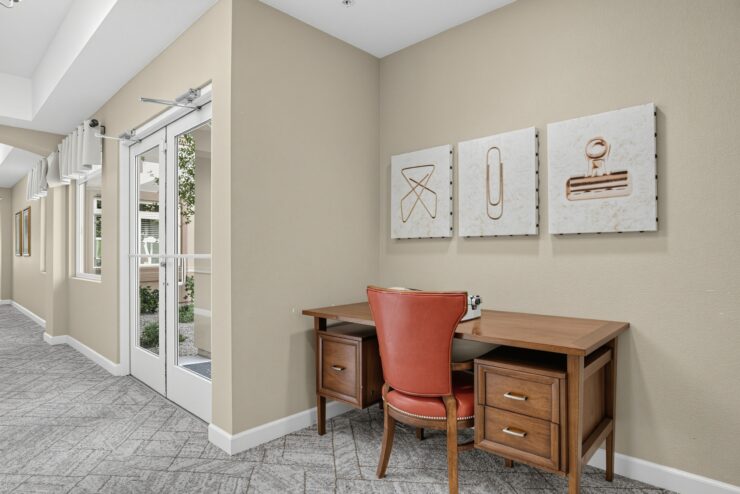 Workstation nook in a well-lit common area with inviting seating and decorative wall art.