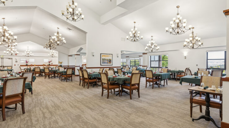 Spacious dining room with elegant chandeliers and plenty of seating for community gatherings.