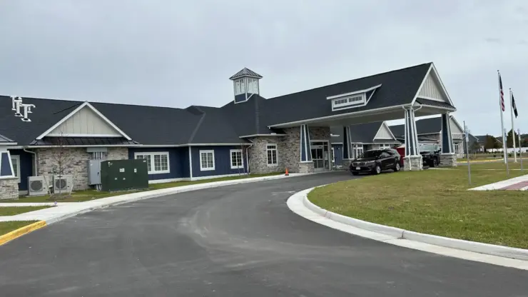 Welcoming retirement community with spacious entrance, peaceful surroundings, and accessible parking.