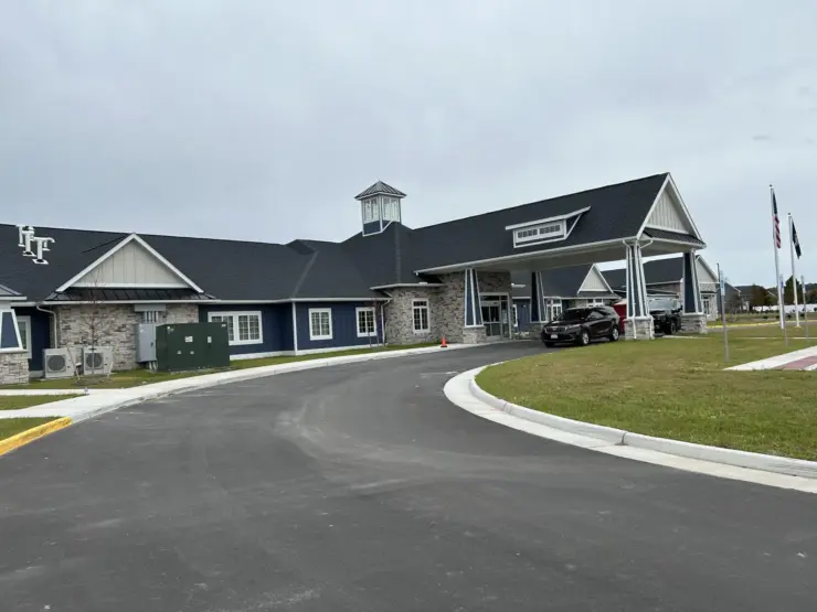 Welcoming retirement community with spacious entrance, peaceful surroundings, and accessible parking.