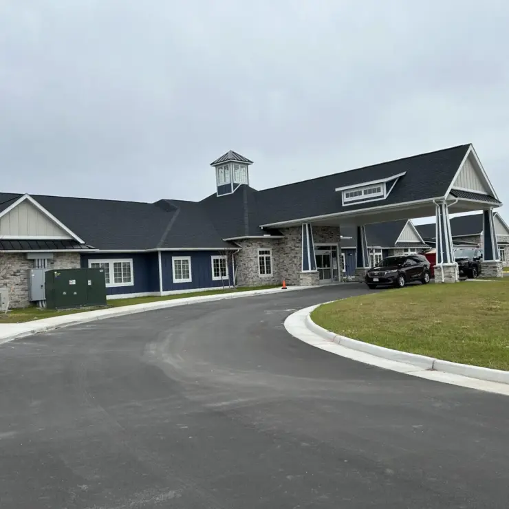 Welcoming retirement community with spacious entrance, peaceful surroundings, and accessible parking.