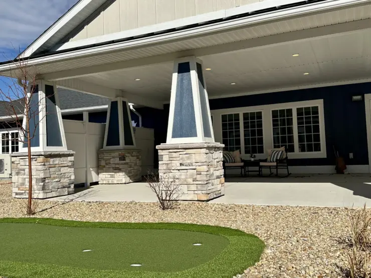 Inviting covered patio with comfortable seating overlooking a putting green and peaceful landscaping.