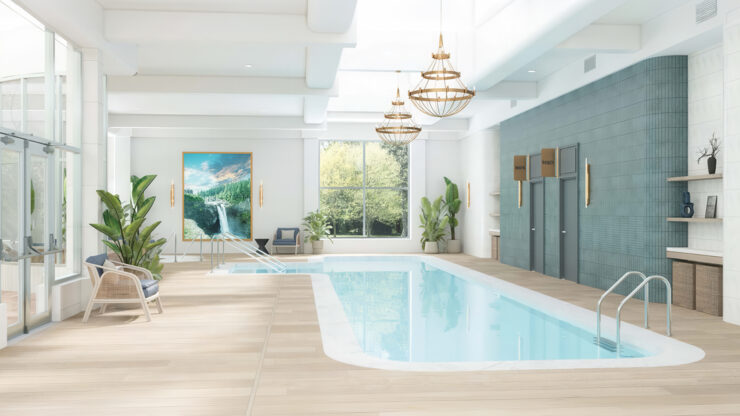 Bright indoor pool area with comfortable seating, greenery, and natural light for relaxation.