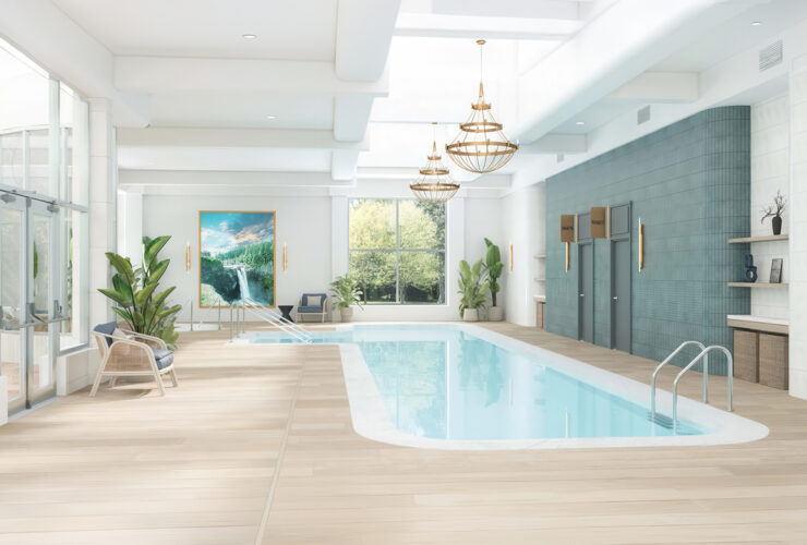 Bright indoor pool area with comfortable seating, greenery, and natural light for relaxation.