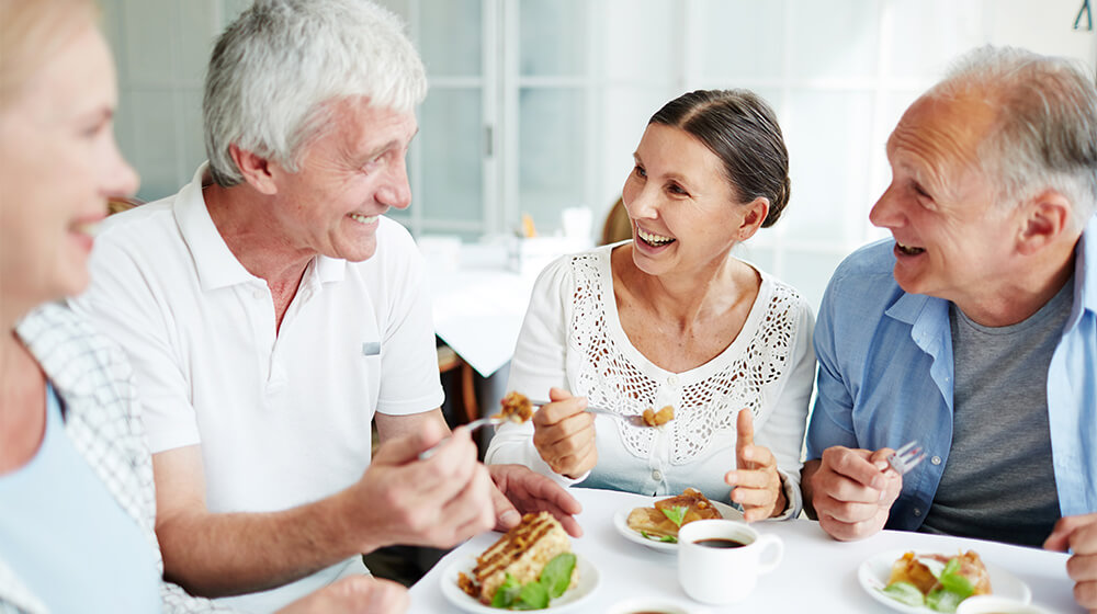Mature friends gather for lunch and share laughs