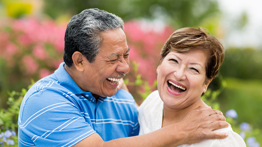 Senior Apartments in Scottsdale, Hispanic couple laughs in scenic meadow