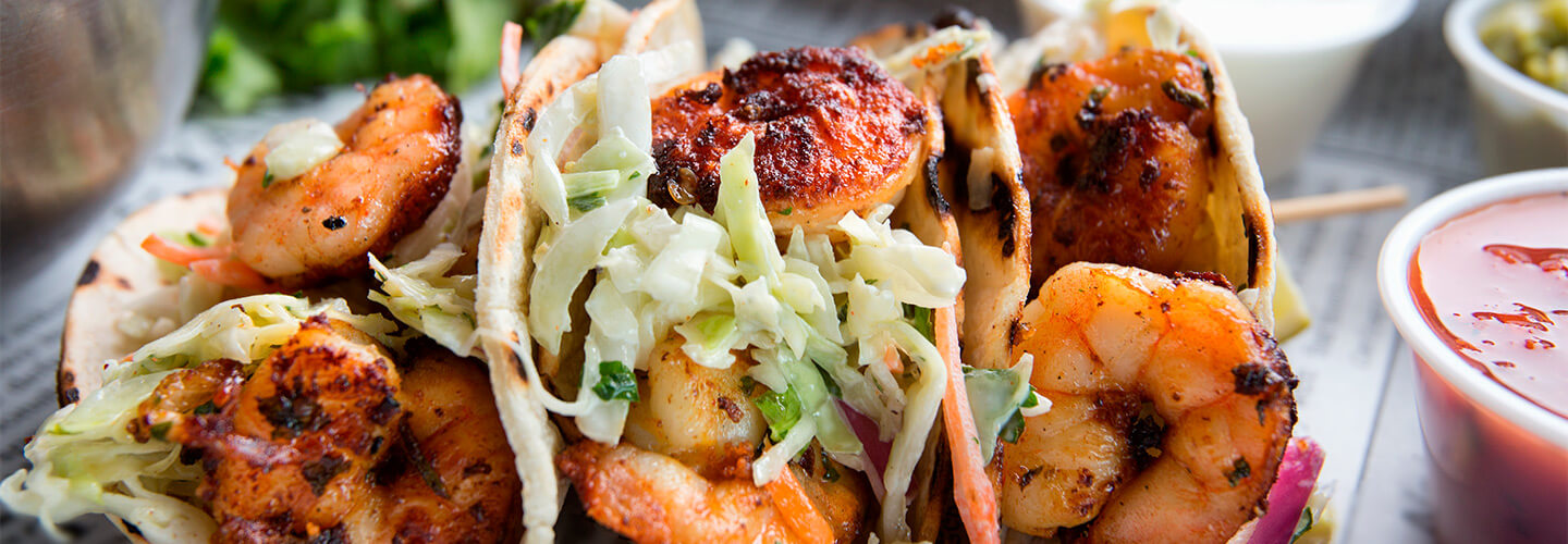 Crispy shrimp tacos with savory sauces are prepared