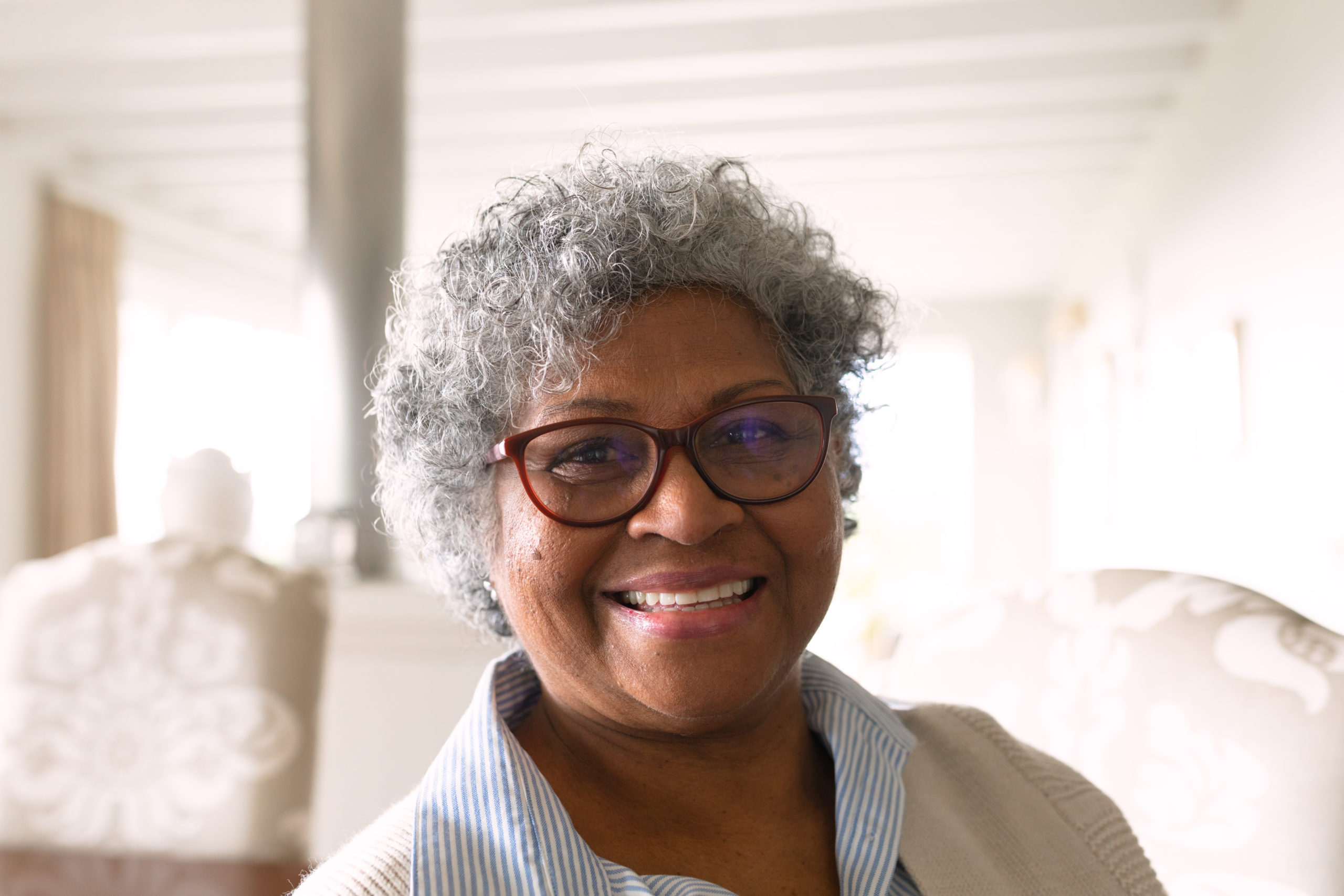 Black elderly woman with red glasses smiling