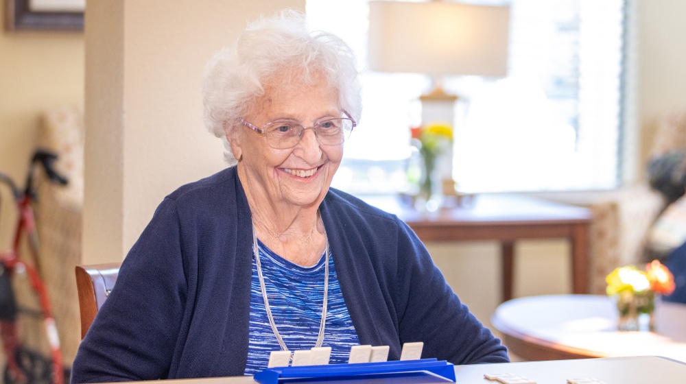 assisted living Turlock, senior woman playing a board game